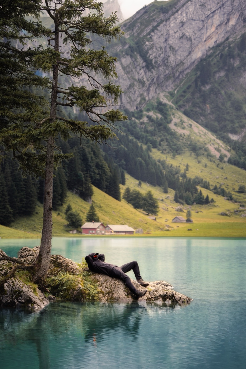 Seealpsee, un lac de montagne lisse comme un miroir sous le Säntis, avec des prairies vertes au bord.